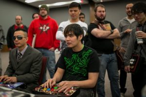 Two players are competing while other attendees are watching during Canada Cup Gaming